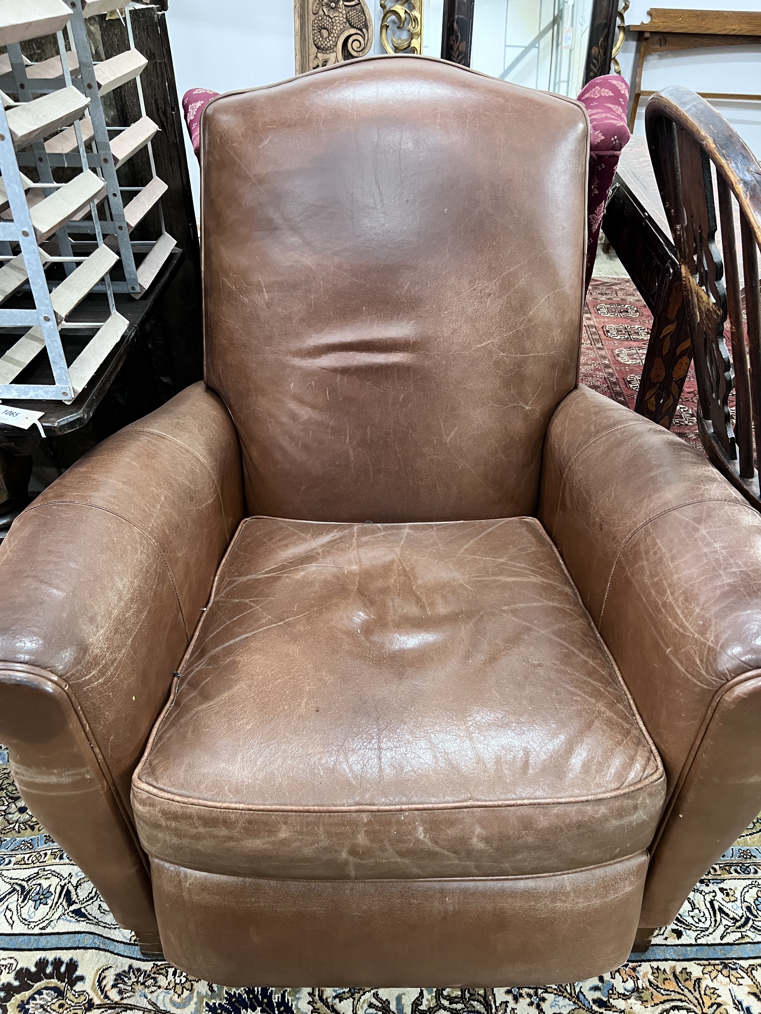 A contemporary tan leather reclining armchair with integral footrest, width 92cm, height 104cm *Please note the sale commences at 9am.